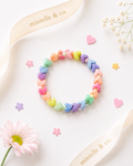Colorful bracelet on a white surface with flowers and 'minielle & co.' branding.