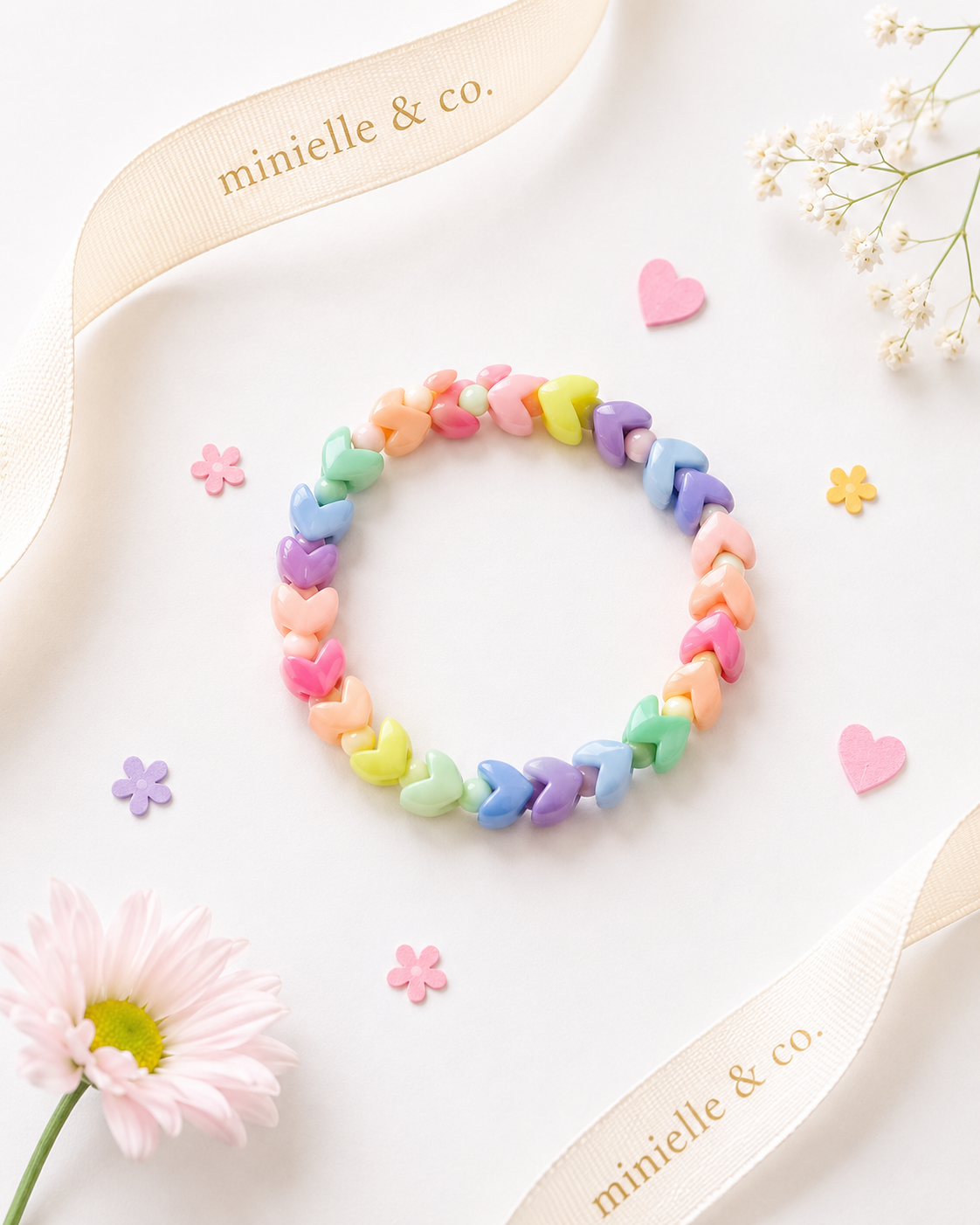 Colorful bracelet on a white surface with flowers and 'minielle & co.' branding.