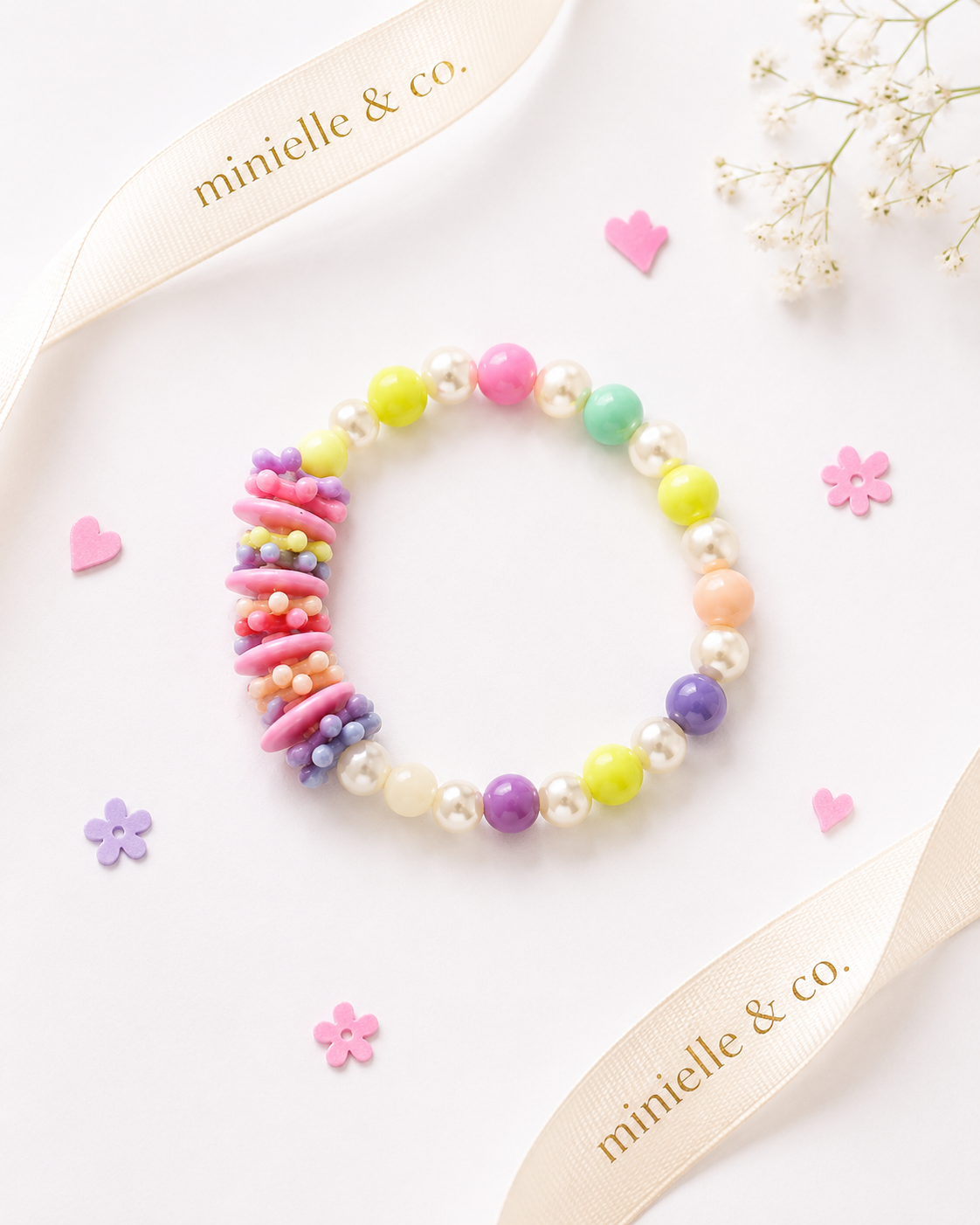Colorful beaded bracelet on a white surface with 'minielle & co.' branding.